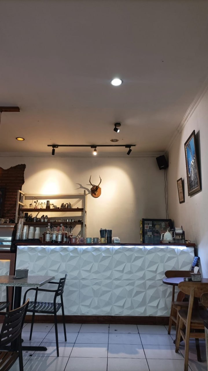 Interior counter Mazalat — panel geometris, pencahayaan hangat